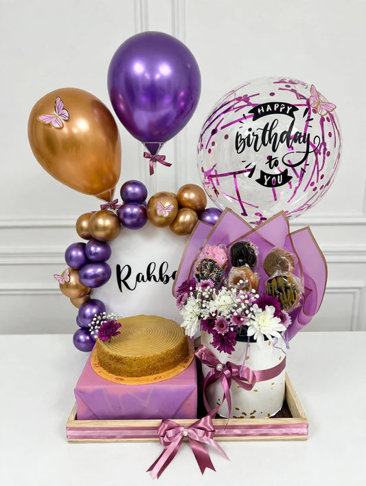 Birthday celebration gift box with cake balloons flowers and sweet treats