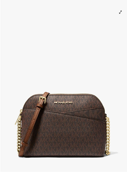 Michael Kors brown monogram crossbody bag with a gold chain strap and gold logo lettering on the front, set against a plain white background.