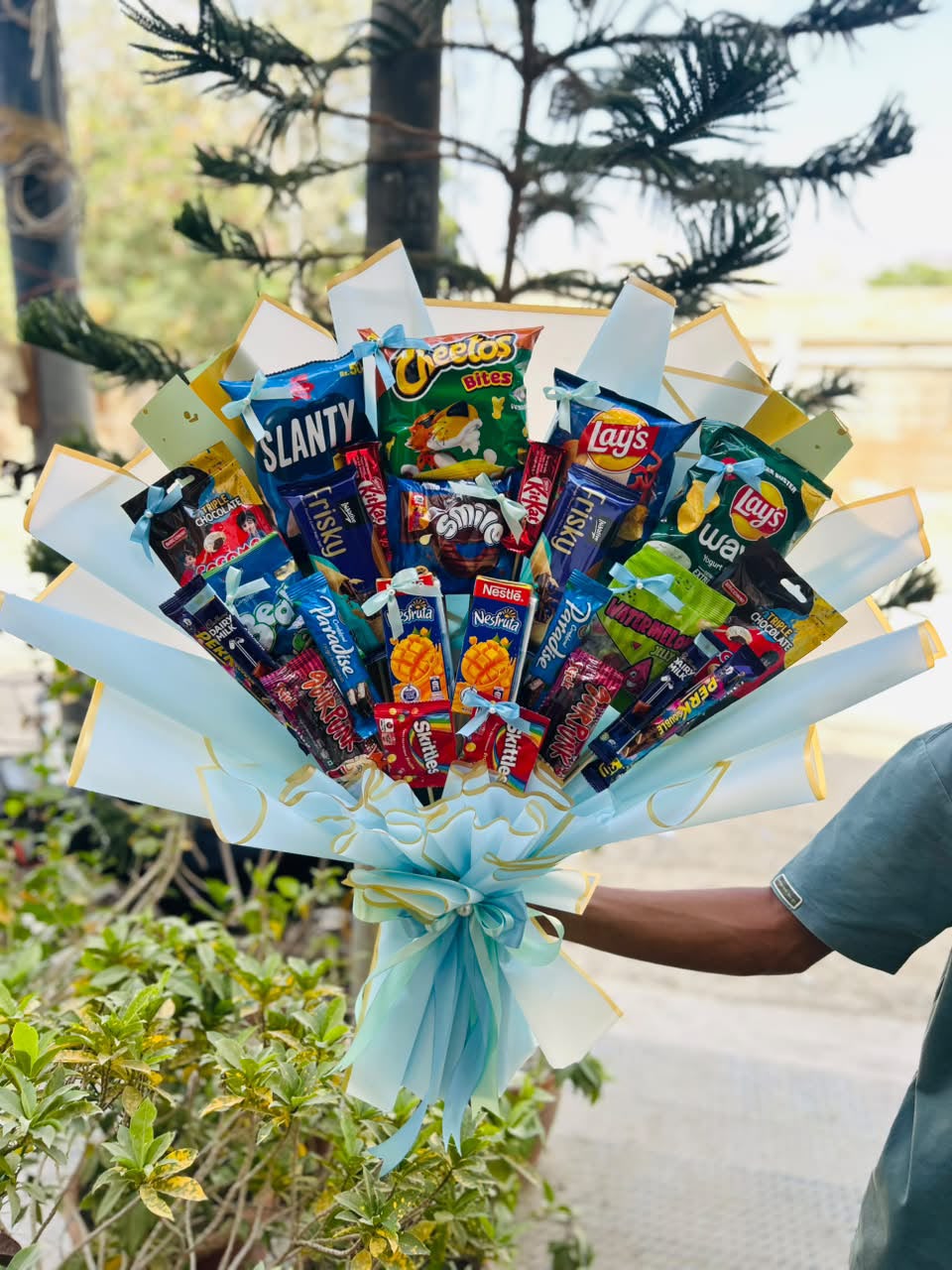 Premium snacks bouquet with chips, chocolates, biscuits and blue ribbon wrapping