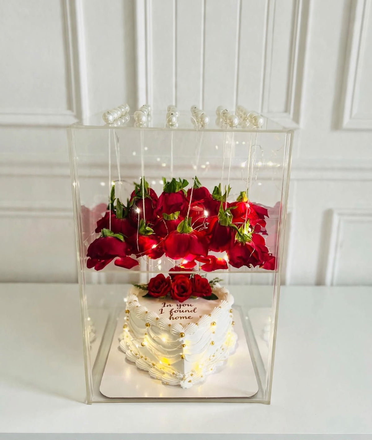 Red roses and heart shaped cake in illuminated gift box
