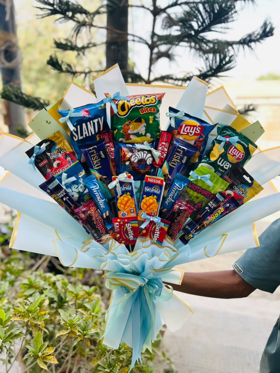Premium snacks bouquet with chips, chocolates, biscuits and blue ribbon wrapping