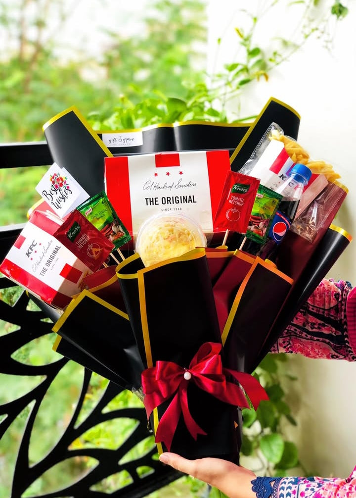 Luxury KFC bouquet gift hamper with fried chicken, fries, Pepsi, coleslaw, sauces, premium black wrapping, and satin ribbon.